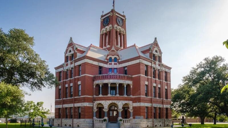Historic Lee County Courthouse in Giddings, Texas with red brick architecture and clock tower