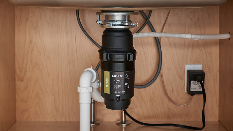 Moen garbage disposal unit installed under kitchen sink - Warren Brothers Plumbing serves Bastrop, Austin, and Elgin TX