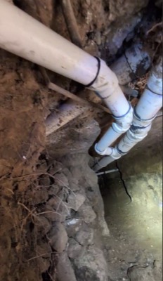 Sewer pipes exposed in excavated trench during repair work - Warren Brothers Plumbing serves Bastrop, Austin, and Elgin TX