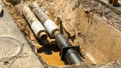 Sewer pipes exposed in excavated trench during repair work - Warren Brothers Plumbing serves Bastrop, Austin, and Elgin TX