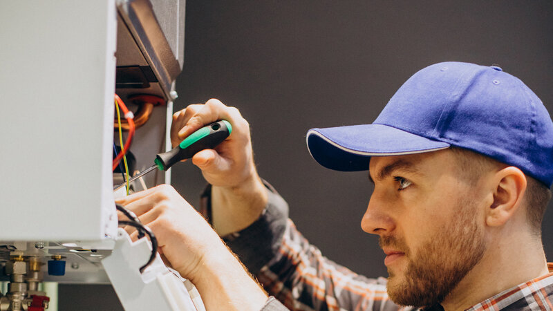 Professional plumber installing tankless water heater in Central Texas home - Warren Brothers Plumbing serves Bastrop, Austin, and Elgin
