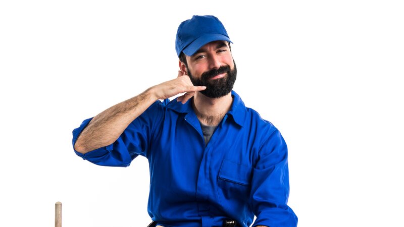 Friendly plumber making call me gesture for virtual Tele-Plumb support - Warren Brothers Plumbing serves all of Texas