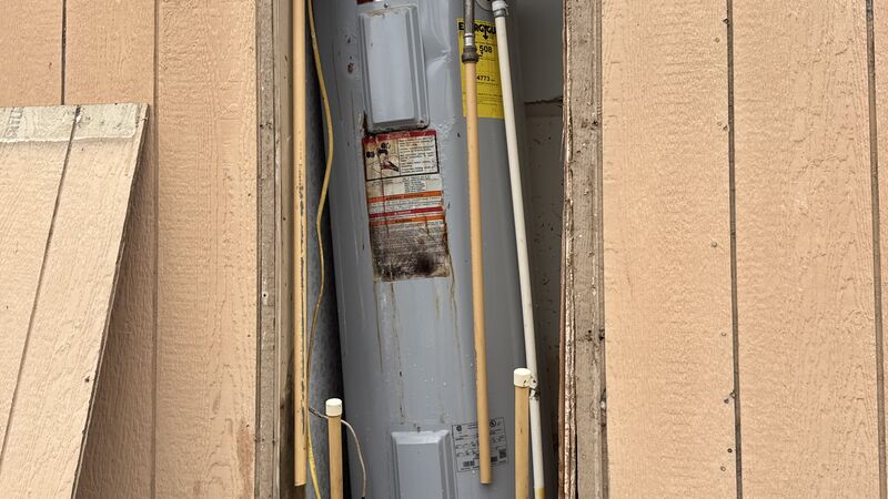 Water heater needing repair in outdoor utility closet - Warren Brothers Plumbing serves Bastrop, Austin, and Elgin TX